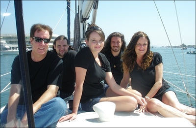 [Lauren, her husband, and her two sons and daughter on a sailboat in a sunny harbor]